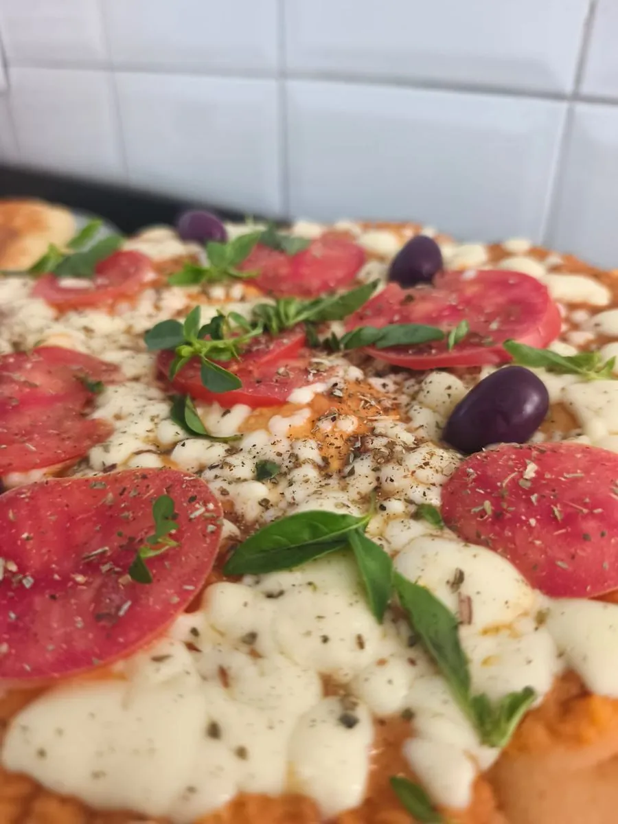 Pizza artesanal com tomate, azeitona e manjericão
