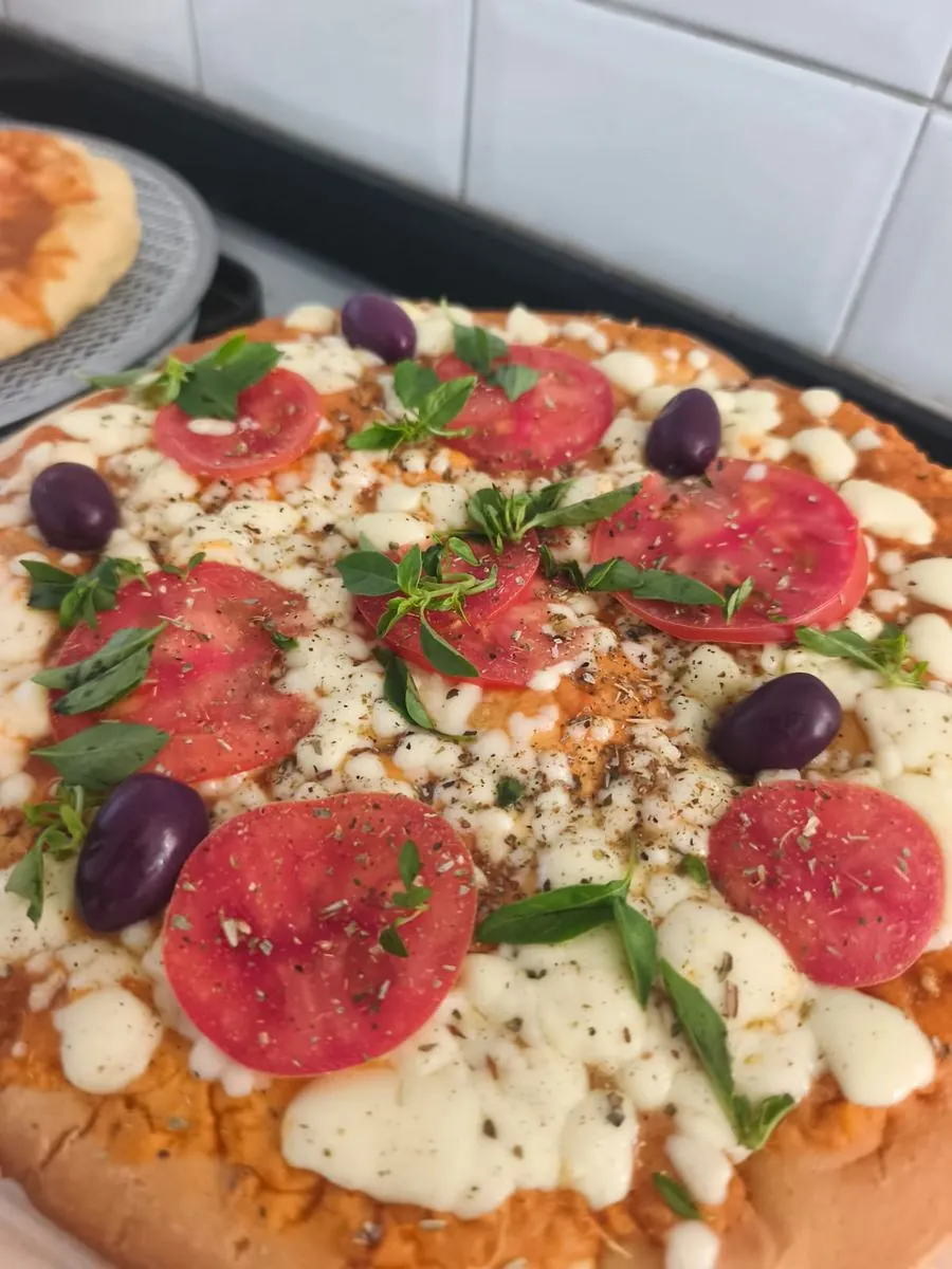 Detalhe de pizza artesanal com tomate e azeitonas pretas