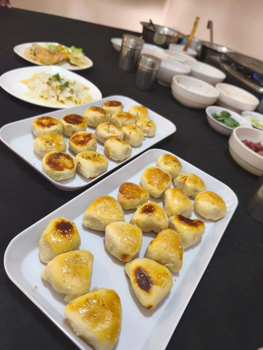 Pães de queijo e massas ao molho branco montados para servir